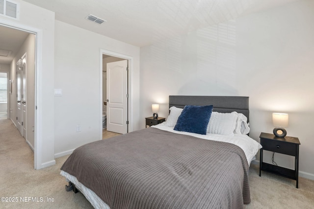 bedroom featuring baseboards, visible vents, attic access, and light colored carpet