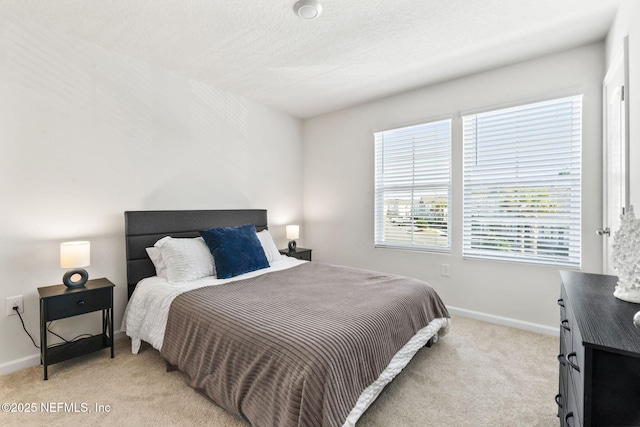 bedroom with baseboards and light colored carpet