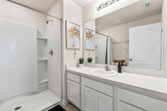 full bathroom featuring a stall shower, vanity, and visible vents