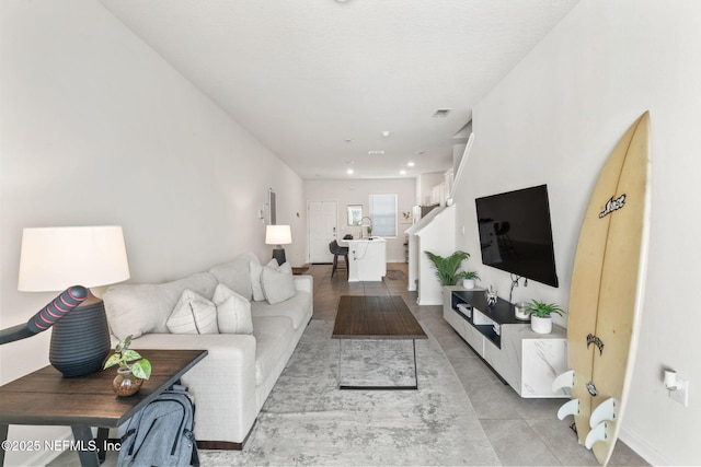 living area with recessed lighting and light tile patterned floors