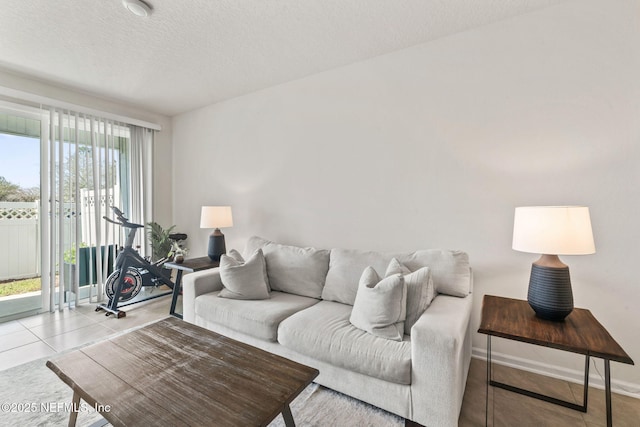 living area with a textured ceiling, baseboards, and tile patterned floors