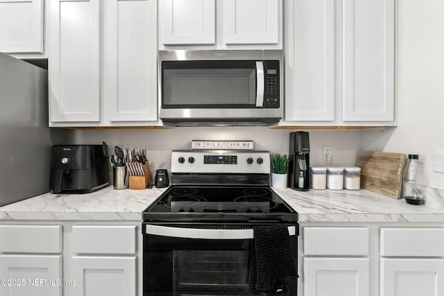 kitchen with light countertops, appliances with stainless steel finishes, and white cabinetry