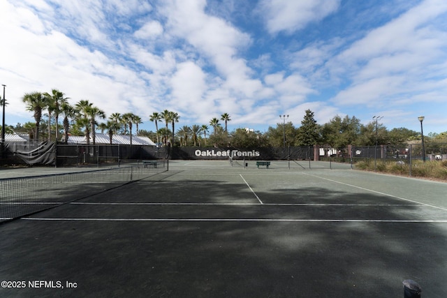 view of tennis court featuring fence