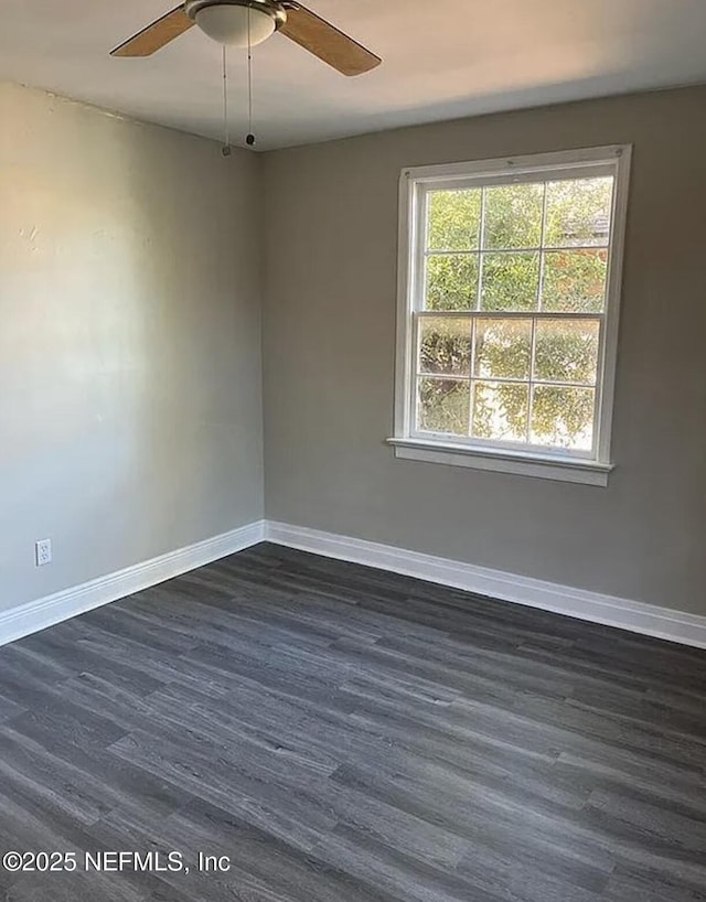 unfurnished room with a ceiling fan, baseboards, and dark wood-style flooring