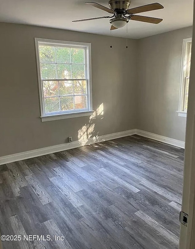 spare room with a ceiling fan, baseboards, and dark wood-type flooring