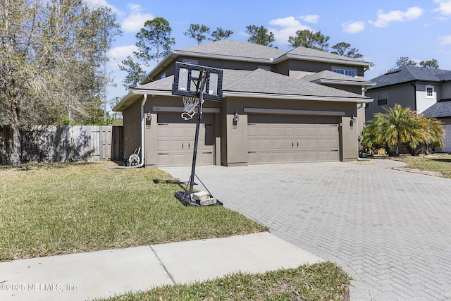 view of front facade with a garage, driveway, a front yard, and stucco siding