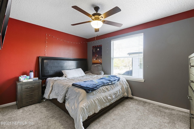 bedroom with a textured ceiling, ceiling fan, baseboards, and light carpet