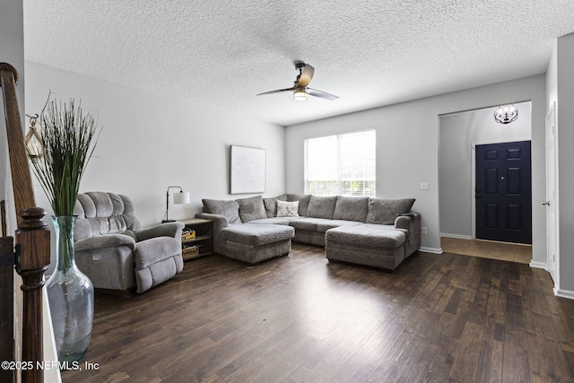 living room with a textured ceiling, baseboards, a ceiling fan, and dark wood-style flooring