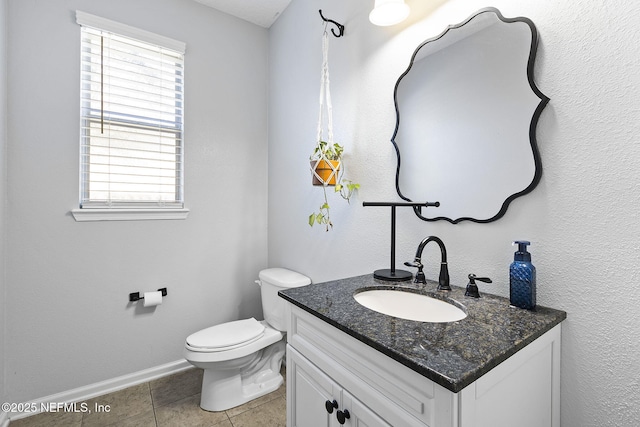 bathroom featuring tile patterned floors, baseboards, toilet, and vanity