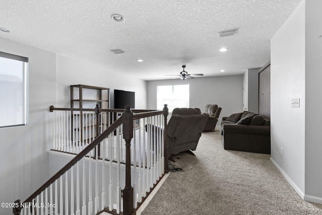 stairway with a ceiling fan, a textured ceiling, recessed lighting, carpet flooring, and baseboards