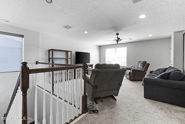 living area with visible vents, ceiling fan, carpet flooring, recessed lighting, and a textured ceiling