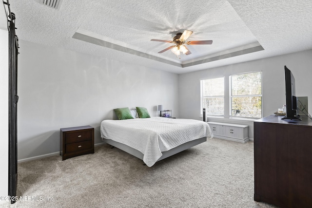 bedroom featuring baseboards, visible vents, a tray ceiling, a textured ceiling, and light carpet