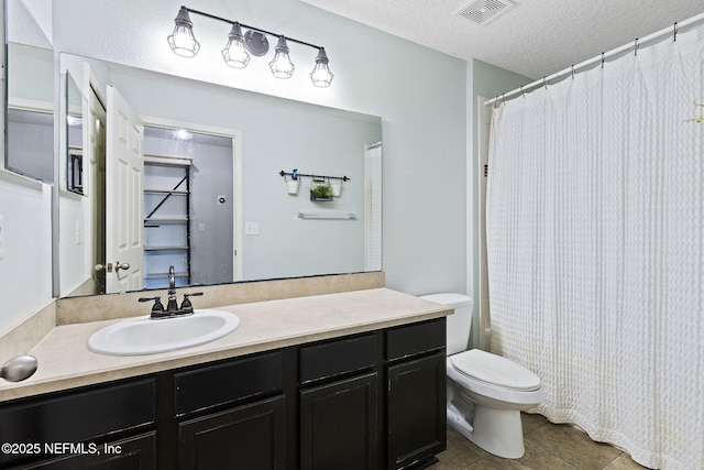 full bath featuring tile patterned flooring, visible vents, toilet, vanity, and a textured ceiling