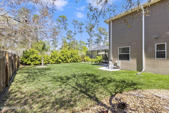 view of yard featuring glass enclosure and fence