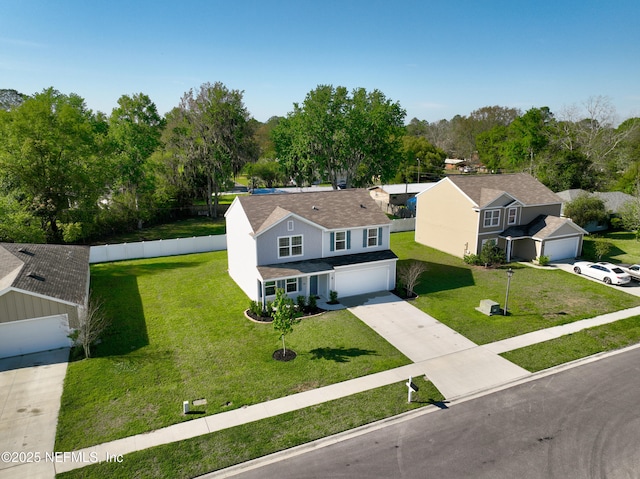 view of front of house featuring a front yard, concrete driveway, a garage, and fence