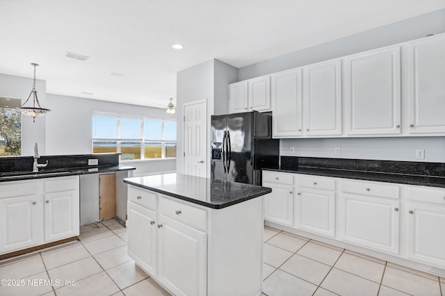 kitchen featuring a sink, white cabinetry, visible vents, and black fridge