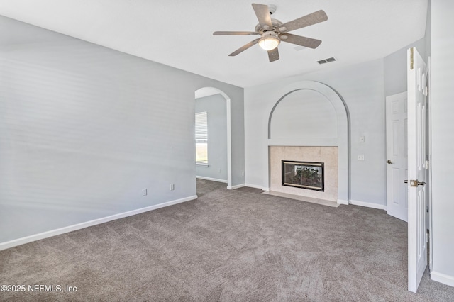 unfurnished living room featuring carpet floors, baseboards, visible vents, and a tiled fireplace