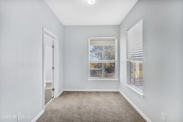 spare room featuring carpet floors and baseboards