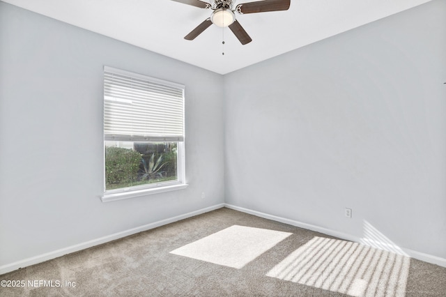 carpeted empty room featuring a ceiling fan and baseboards