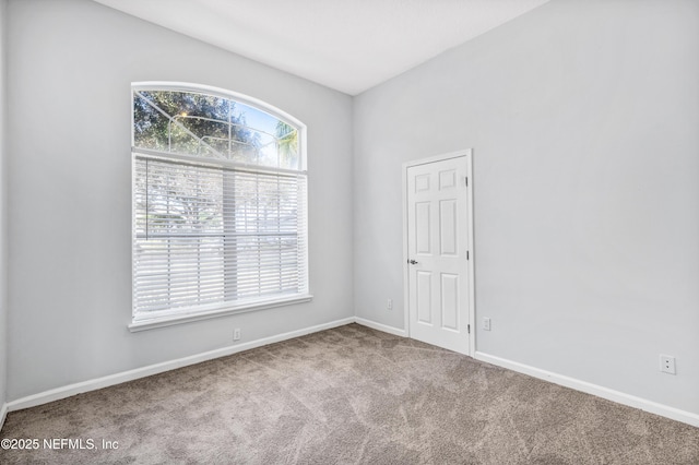 carpeted spare room with baseboards