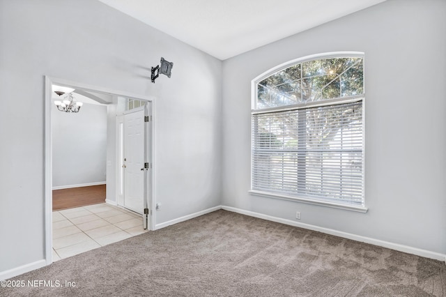 carpeted spare room featuring an inviting chandelier, baseboards, and tile patterned floors