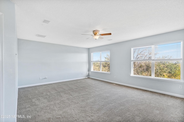 carpeted spare room featuring baseboards, visible vents, and a textured ceiling