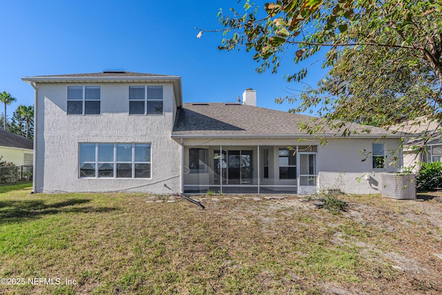 back of property featuring a sunroom, a yard, roof with shingles, stucco siding, and a chimney