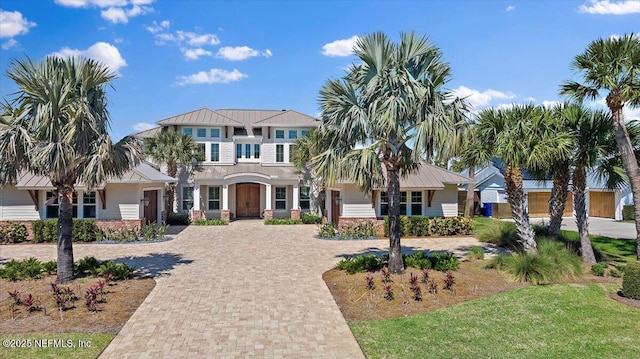 view of front of house featuring metal roof, decorative driveway, and a standing seam roof