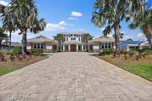 view of front of home featuring metal roof, decorative driveway, and a standing seam roof