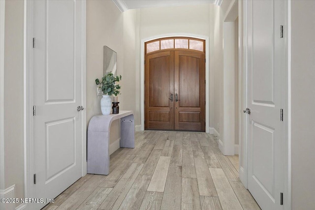 entryway with light wood-style flooring and baseboards