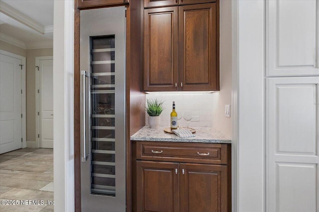 bar featuring wine cooler, tasteful backsplash, and ornamental molding