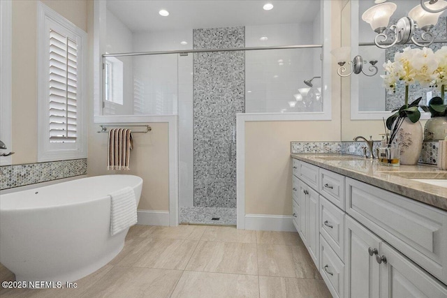 bathroom featuring a freestanding bath, double vanity, a tile shower, recessed lighting, and a sink