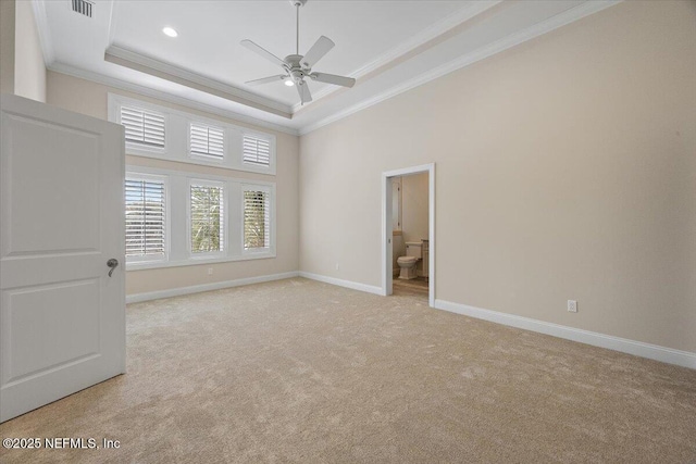 unfurnished bedroom featuring visible vents, crown molding, baseboards, light carpet, and a raised ceiling