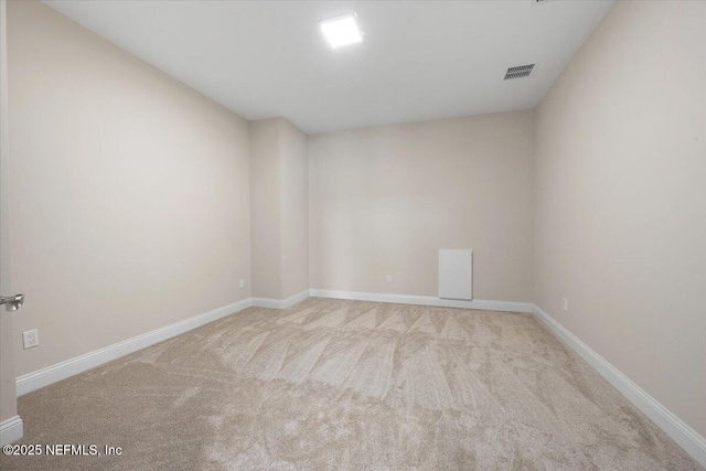 carpeted spare room with visible vents and baseboards