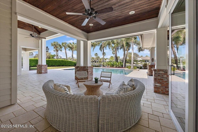 view of patio / terrace with an outdoor pool and a ceiling fan