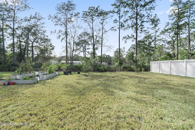 view of yard with a vegetable garden and fence