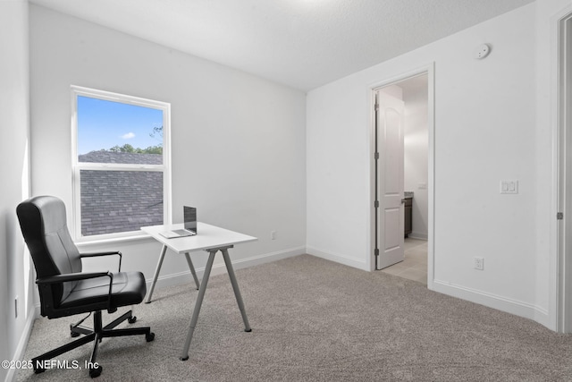 carpeted home office featuring baseboards