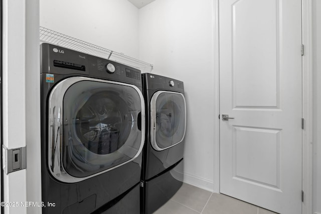 washroom featuring laundry area, separate washer and dryer, and tile patterned flooring