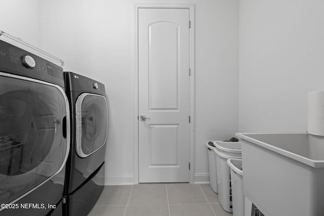 laundry room featuring laundry area, independent washer and dryer, baseboards, and light tile patterned floors