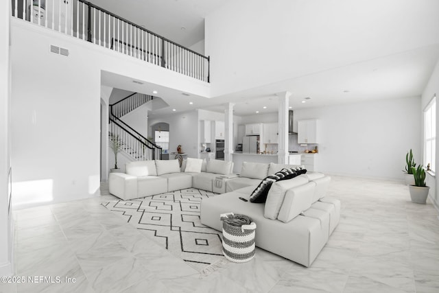 living area with recessed lighting, visible vents, stairs, marble finish floor, and ornate columns