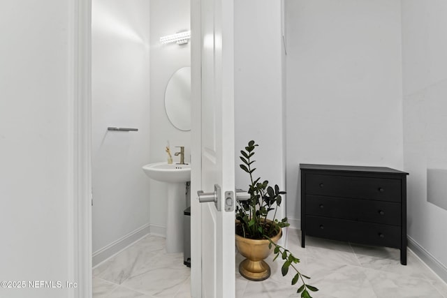 bathroom featuring marble finish floor and baseboards