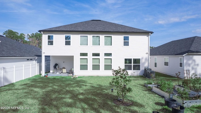 rear view of house with a patio, central AC unit, fence, a garden, and a yard