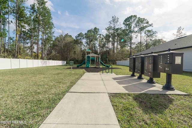 community play area featuring fence and a yard