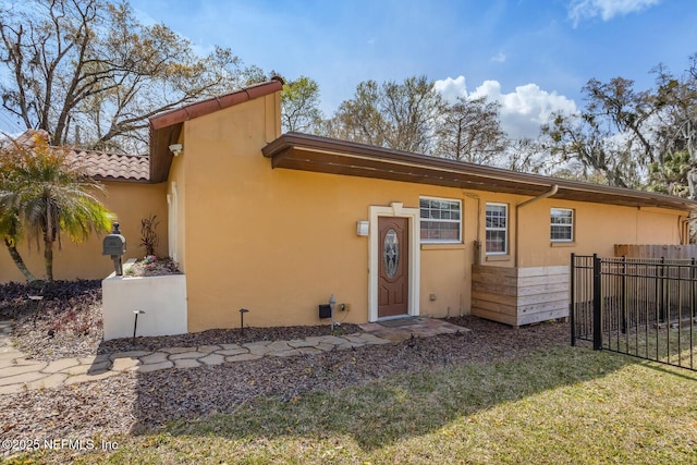 view of front of home with a front yard, fence, and stucco siding