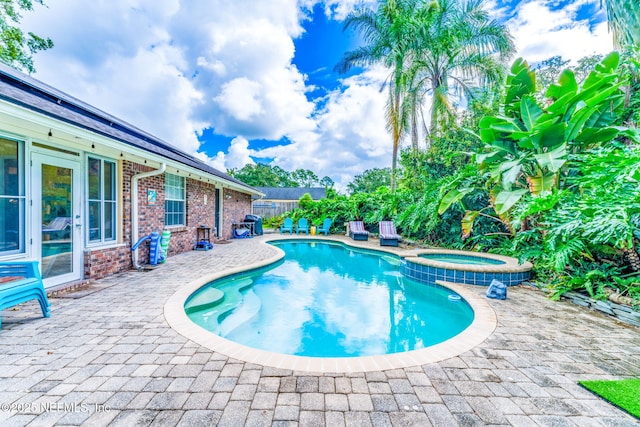 view of pool with a patio area, a fenced backyard, and a pool with connected hot tub