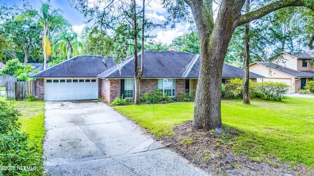 ranch-style house featuring driveway, an attached garage, fence, a front yard, and brick siding