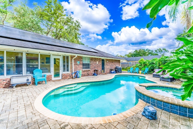 view of swimming pool with a patio area, fence, a fenced in pool, and an in ground hot tub