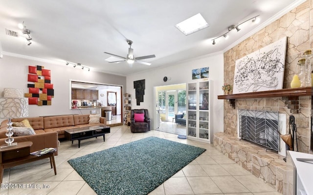 tiled living room featuring crown molding, a fireplace, visible vents, a ceiling fan, and track lighting