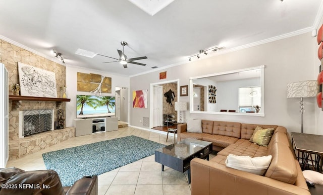 tiled living area with a skylight, a fireplace, crown molding, rail lighting, and a ceiling fan