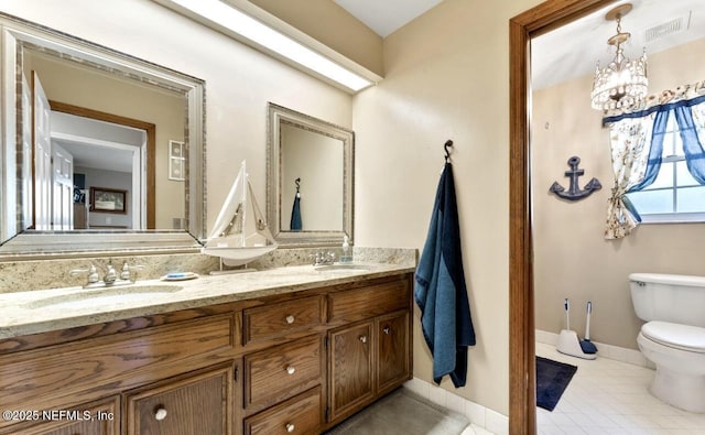 bathroom with toilet, tile patterned flooring, baseboards, and a sink